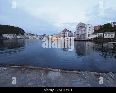 Bâtiments sécessionniste reflète dans l'eau vu de front de ville européenne d'Ålesund à Romsdal, Norvège, au soir Banque D'Images