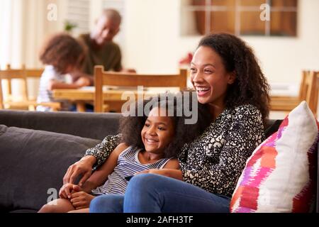 Mother and Daughter Sitting on Sofa At Home Regarder la vidéo sur la télévision ensemble Banque D'Images