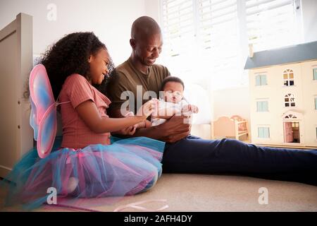 Père et fille assis dans chambre avec petit frère Banque D'Images