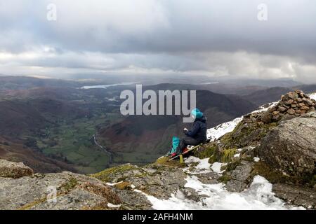 Walker en profitant de la vue le long de Langdale vers Windermere du sommet de Harrison Stickle, Lake District, Cumbria, Royaume-Uni Banque D'Images