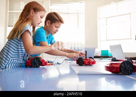 Deux étudiants en informatique de l'école après l'apprentissage de la classe Codage Véhicule Robot Programme Banque D'Images