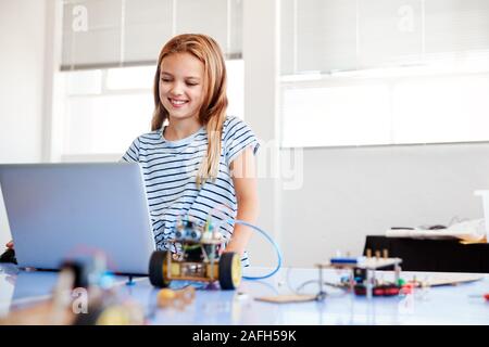 Étudiante Building et de programmation Robot Véhicule en classe après l'École de codage informatique Banque D'Images