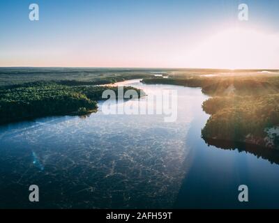 Photo aérienne d'une rivière entourée d'îles couvertes verdure sous la lumière du soleil Banque D'Images