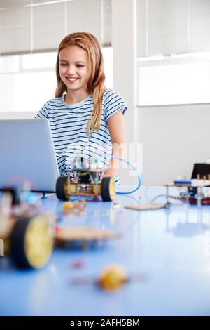 Étudiante Building et de programmation Robot Véhicule en classe après l'École de codage informatique Banque D'Images