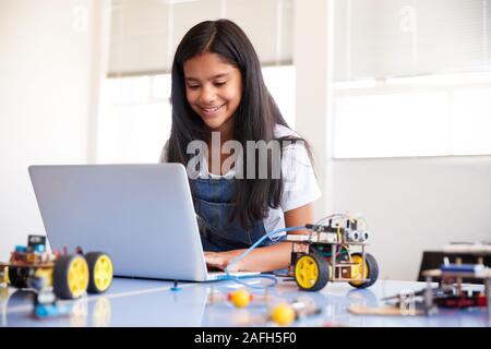 Étudiante Building et de programmation Robot Véhicule en classe après l'École de codage informatique Banque D'Images