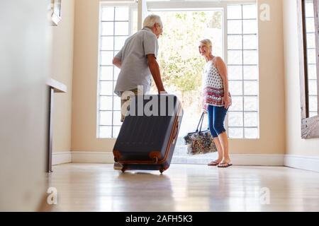 En couple avec valise porte avant sur le point de partir pour des vacances Banque D'Images