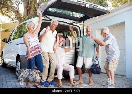 Portrait de Senior Friends charger des bagages dans coffre de voiture sur le point de partir pour des vacances Banque D'Images