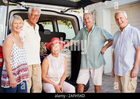 Portrait of Senior Friends Loading Assurance dans coffre de voiture sur le point de partir pour des vacances Banque D'Images