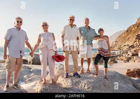 Portrait of Senior Friends Standing sur les roches par la mer sur le groupe d'été Banque D'Images