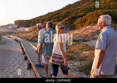 Groupe d'amis marchant le long de l'été sur la plage Promenade de vacances de groupe Banque D'Images