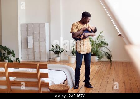 Père aimant Holding Newborn Baby à la maison dans cet appartement Loft Banque D'Images