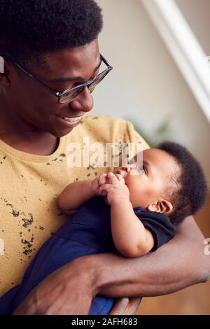 Père aimant Holding Newborn Baby à la maison dans cet appartement Loft Banque D'Images