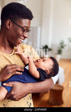 Père aimant Holding Newborn Baby à la maison dans cet appartement Loft Banque D'Images