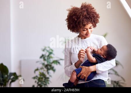 Loving Mother Holding Newborn Baby à la maison dans cet appartement Loft Banque D'Images