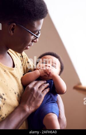 Père aimant Holding Newborn Baby à la maison dans cet appartement Loft Banque D'Images