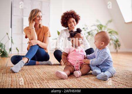Deux mères Réunion pour jouer avec les bébés Date à la maison dans cet appartement Loft Banque D'Images