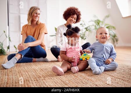 Deux mères Réunion pour jouer avec les bébés Date à la maison dans cet appartement Loft Banque D'Images