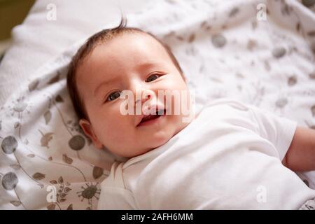 Smiling Baby Boy Lying On Bed At Home Smiling at Camera Banque D'Images