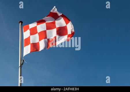 Drapeau à damier rouge et blanc du Brabant-septentrional la partie sud des Pays-Bas forme sur un ciel bleu Banque D'Images