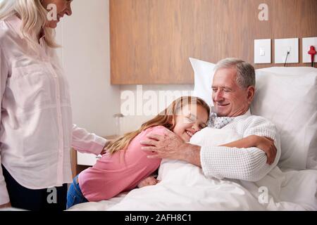 Granddaughter Hugging Grand-père sur la visite à l'hôpital. Banque D'Images