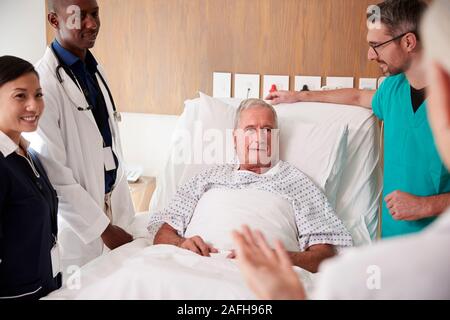 L'équipe médicale sur Tours rencontre autour du lit Senior Male Patient Banque D'Images