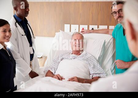 L'équipe médicale sur Tours rencontre autour du lit Senior Male Patient Banque D'Images