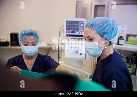 L'équipe chirurgicale des femmes travaillant sur le patient à l'Hôpital d'opération Banque D'Images