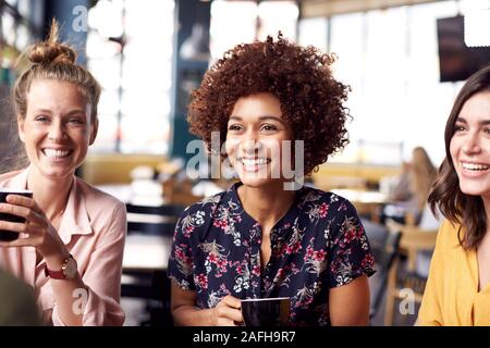 Trois jeunes femmes Réunion d'amis autour de la table à café et parler Banque D'Images