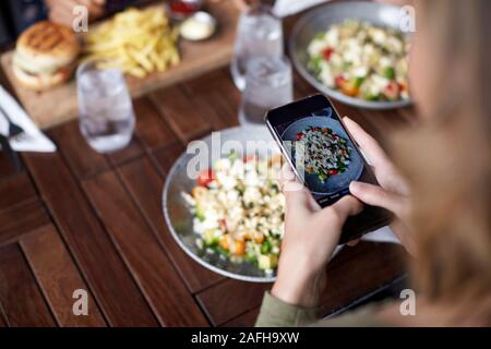 Les Amis des femmes dans la prise de photo de Restaurant La cuisine du restaurant pour publier sur les médias sociaux Banque D'Images