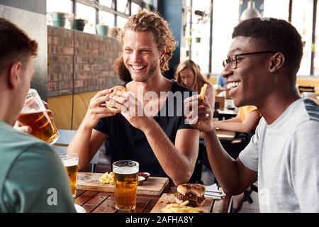 Trois jeunes amis réunion pour les boissons au restaurant Banque D'Images