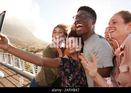 Smiling Young Friends Posing pour passerelle extérieure Selfies sur l'ensemble Banque D'Images