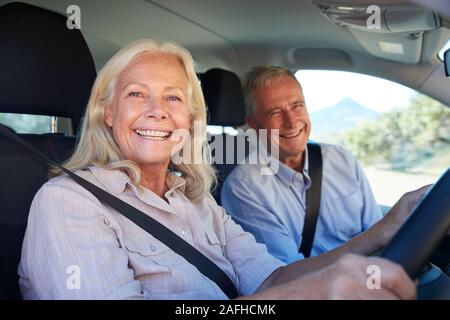 Hauts femme blanche et son mari dans leur voiture conduite smiling to camera, Close up, side view Banque D'Images