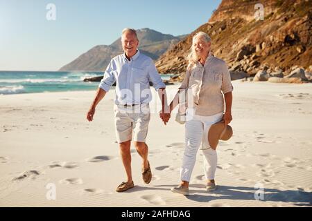 Blanc Senior couple en train de marcher sur une plage ensemble se tenant la main, pleine longueur, Close up Banque D'Images