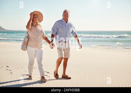 Blanc Senior couple en train de marcher sur une plage ensemble se tenant la main, pleine longueur, Close up Banque D'Images