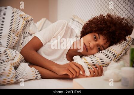 Millennial African American woman malade au lit à la recherche d'appareil photo, Close up Banque D'Images