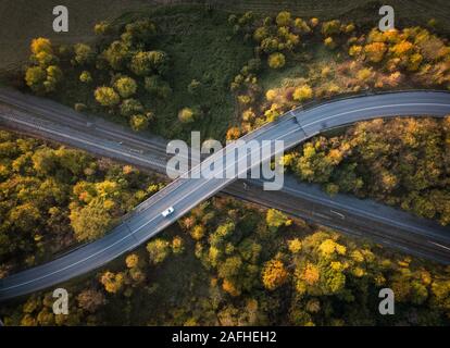 Route sinueuse dans la forêt d'automne au coucher du soleil dans les montagnes. Vue aérienne. Vue de dessus de belle chaussée asphaltée et d'orangers. Grâce à l'autoroute woodlan Banque D'Images