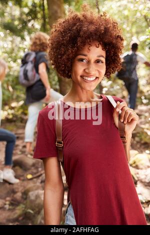 Smiling African American Woman millénaire de la randonnée dans une forêt, jusqu'à la taille, Close up, vertical Banque D'Images