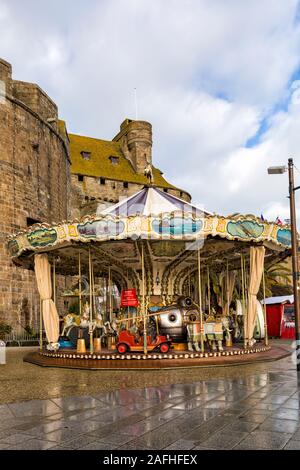 Carousel merry-go-round avec château de la Duchesse Anne de Bretagne, à St Malo, Saint Malo, Bretagne, France en Décembre Banque D'Images