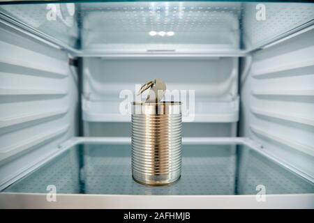 Voir à l'intérieur réfrigérateur vide sauf pour Ouvrir boite de conserve sur une étagère Banque D'Images