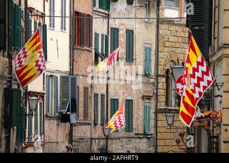 Sienne, Italie. La vieille ville est divisée en quartiers (contrade) traditionnel avec des drapeaux et couleurs. Valdimontone (vallée de la Ram). Banque D'Images