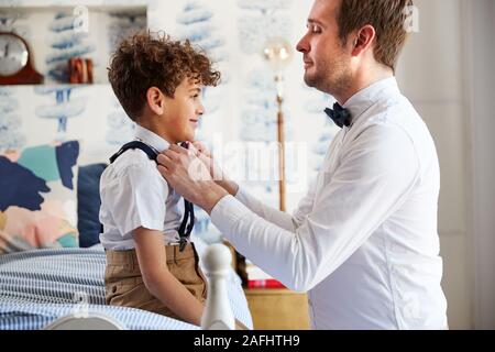 Père et Fils portant des tenues correspondant se préparer pour le mariage à la maison Banque D'Images