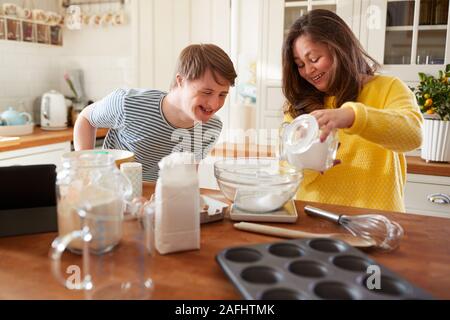 Le syndrome de Down jeune couple Baking In Kitchen At Home Banque D'Images