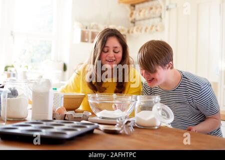 Le syndrome de Down jeune couple Baking In Kitchen At Home Banque D'Images