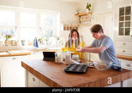 Le syndrome de Down jeune couple Baking In Kitchen At Home Banque D'Images