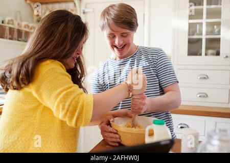 Le syndrome de Down jeune couple Baking In Kitchen At Home Banque D'Images