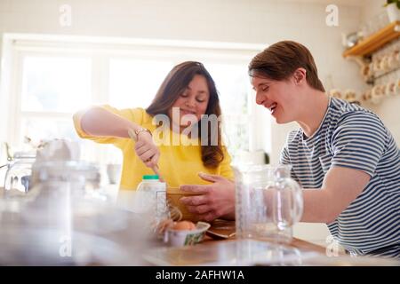 Le syndrome de Down jeune couple Baking In Kitchen At Home Banque D'Images