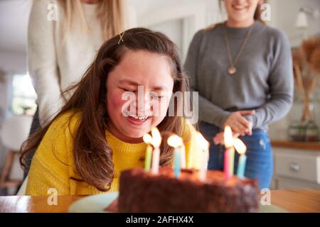 Jeune femme Trisomie célébrer anniversaire à la maison avec du gâteau Banque D'Images