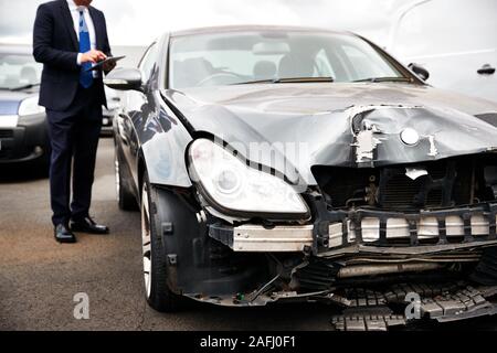 Sinistres Assurance mâle avec tablette numérique l'inspection des dommages au moteur de voiture Accident Banque D'Images