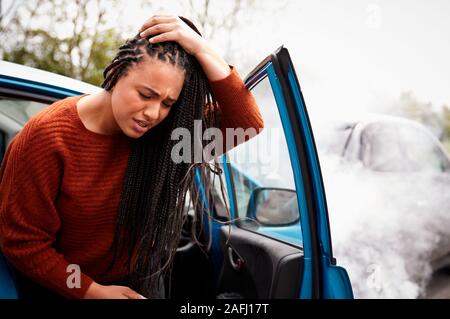 Femme Automobiliste avec une blessure à la tête en sortant de la voiture après accident Banque D'Images