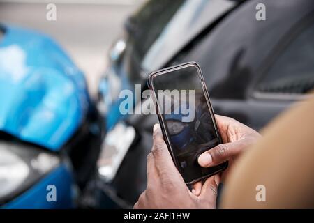 Automobiliste mâle impliqué dans Accident de voiture Prendre photo de dommages pour réclamation d'assurance Banque D'Images